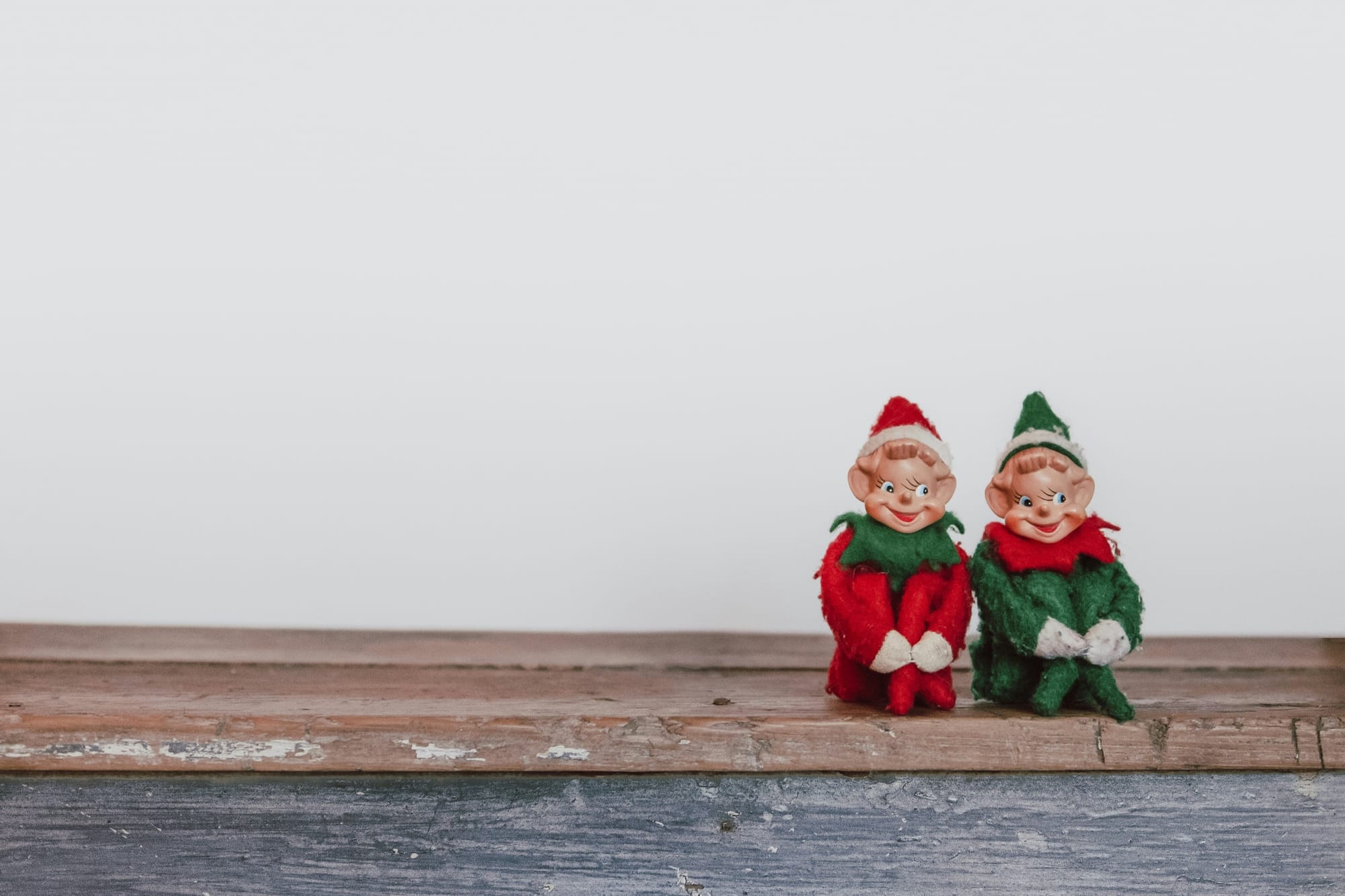 Two vintage elf decorations with an unsettling appearance, representing the darker interpretations of holiday traditions in art.