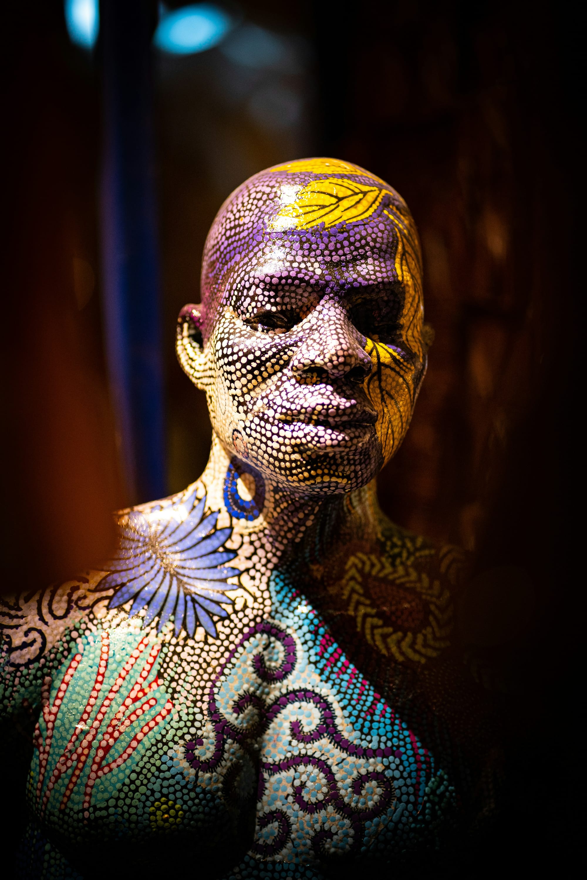 A mannequin beautifully painted with intricate patterns and vibrant colors.